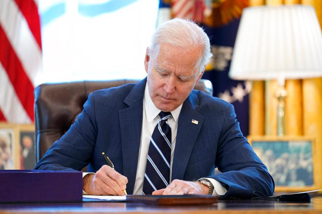 President Joe Biden signs the American Rescue Plan, a coronavirus relief package, in the Oval Office of the White House