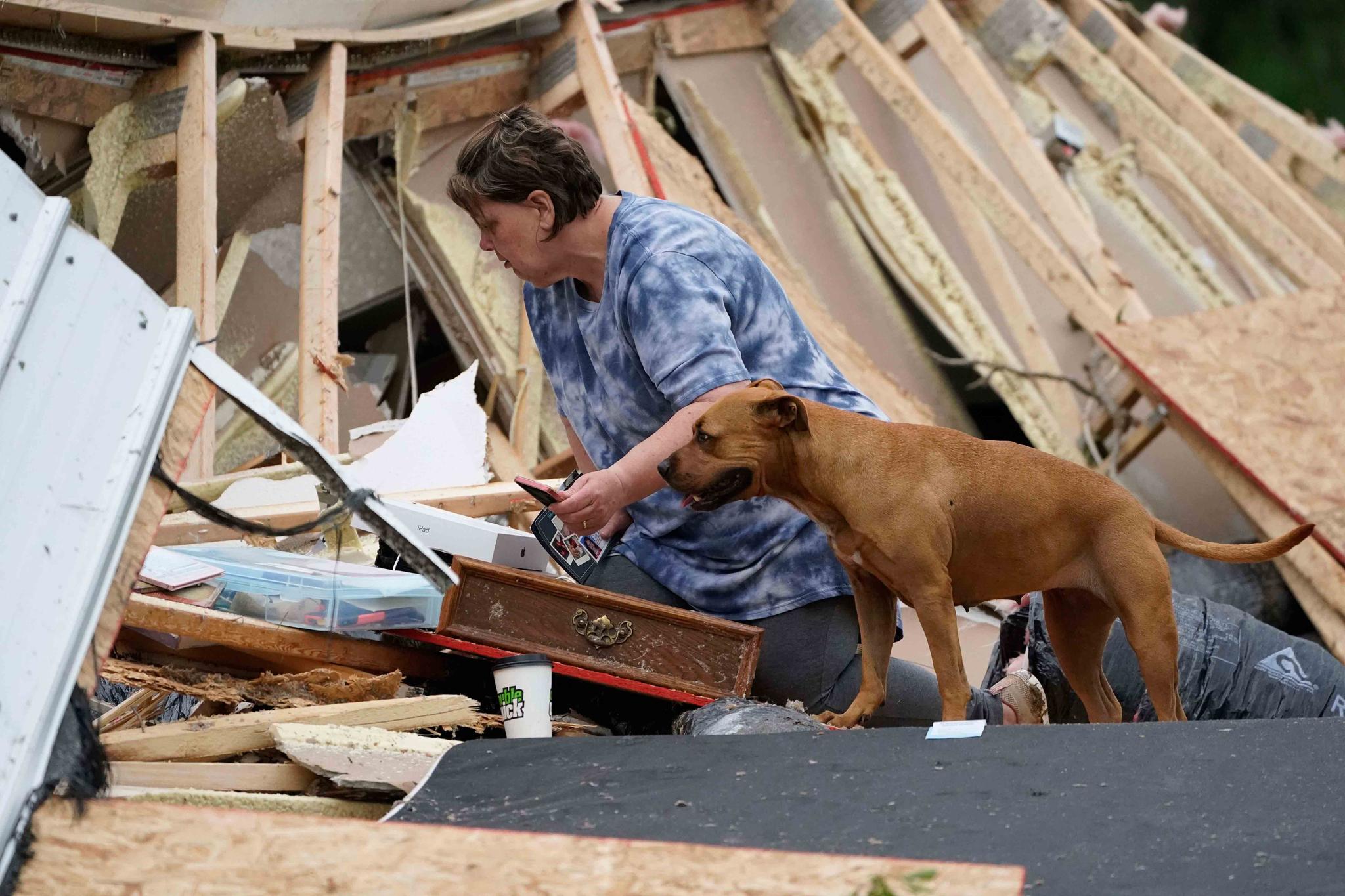 Vickie Savell looks through her belongings amid the remains of her new mobile home early Monday, May 3, 2021, in Yazoo County, Miss.