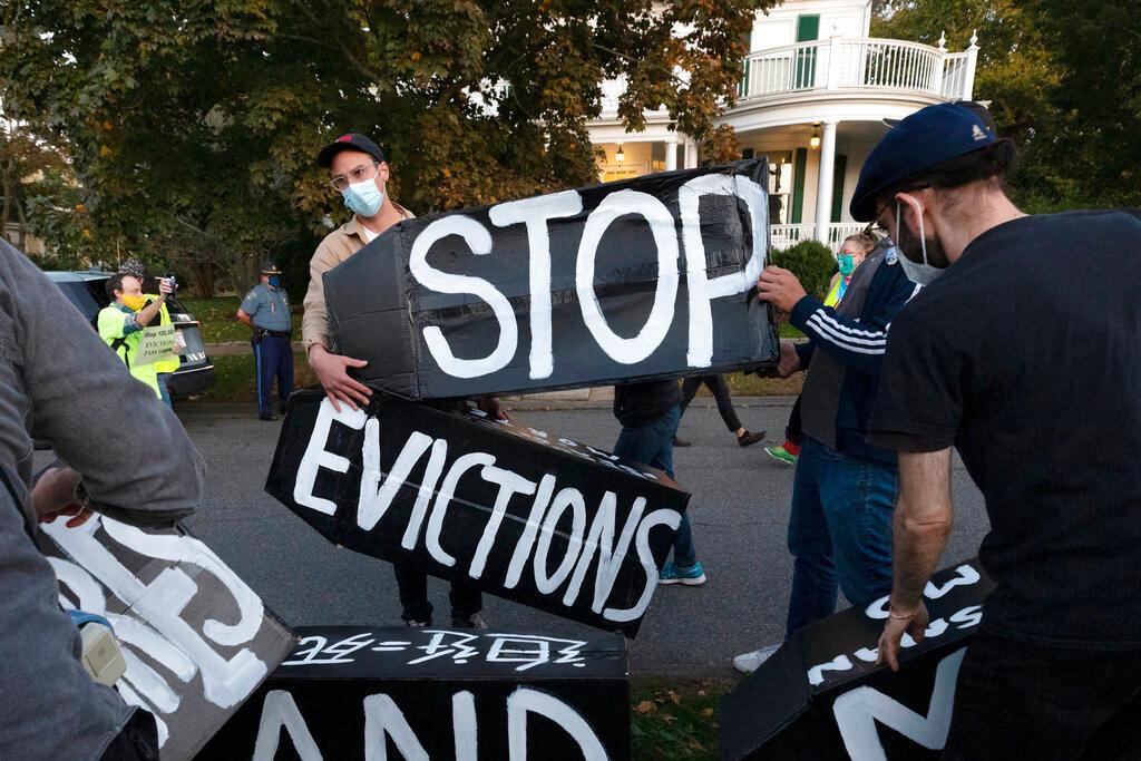In this Oct. 14, 2020, file photo, housing activists erect a sign in front of Massachusetts Gov. Charlie Baker's house in Swampscott, Mass. A federal judge has ruled, Wednesday, May 5, 2021, that the Centers for Disease Control exceeded its authority when it imposed a federal eviction moratorium to provide protection for renters out of concern that having families lose their homes and move into shelters or share crowded conditions with relatives or friends during the pandemic would further spread the highly contagious virus.
