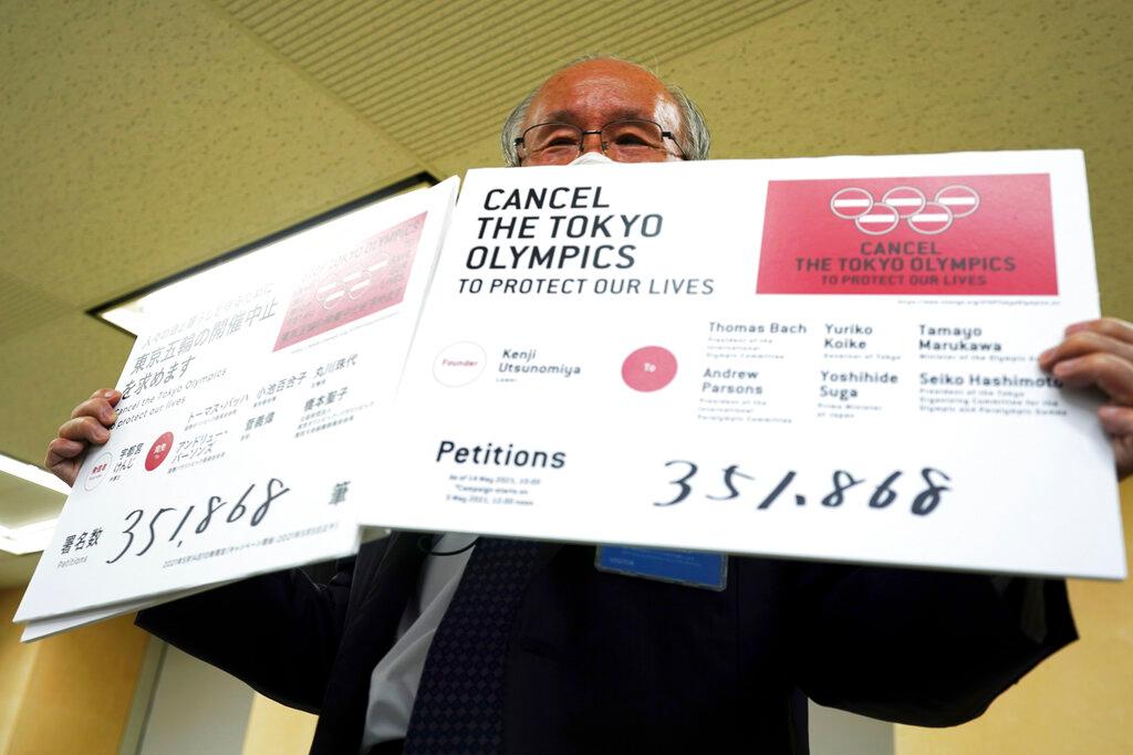 Lawyer Kenji Utsunomiya, a representative of an anti-Olympics group, holds boards showing the current figure of online petition