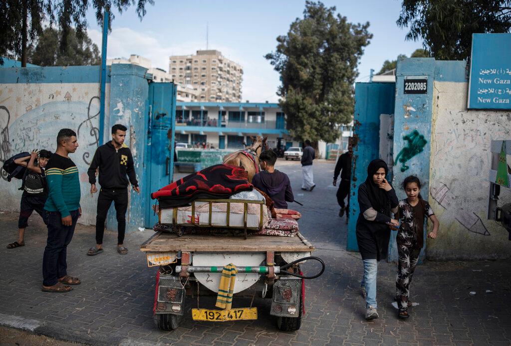 Palestinians flee their homes to a U.N. school after overnight Israeli heavy missile strikes on their neighborhoods in the outskirts of Gaza City