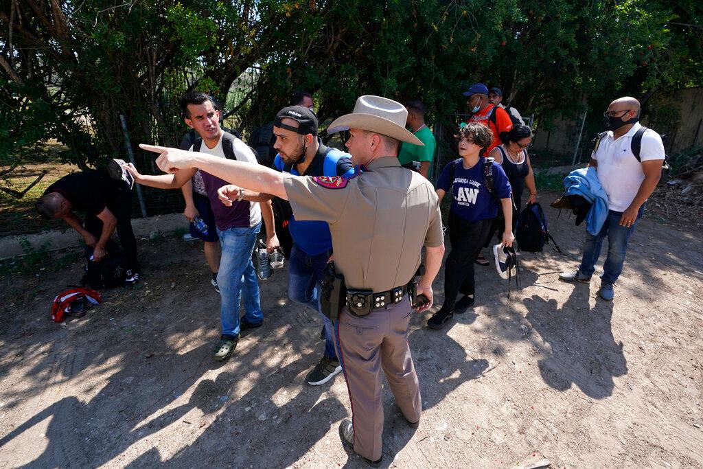Texas Trooper and Migrants at Border 