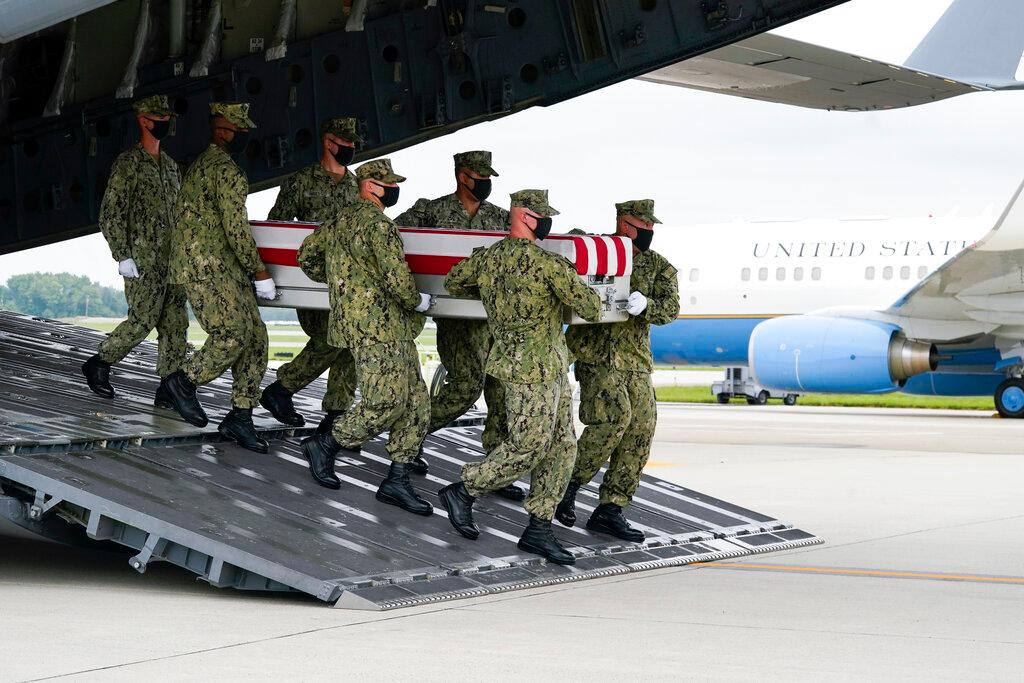 A Navy carry team moves a transfer case containing the remains of Navy Corpsman Maxton W. Soviak