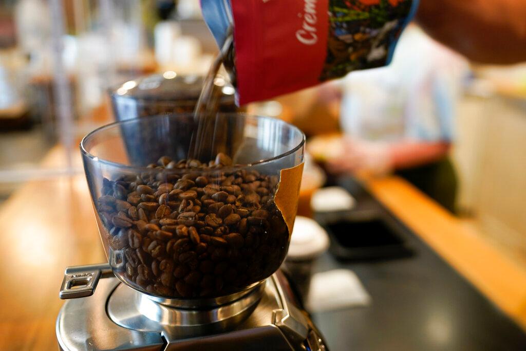 Chris Vigilante refills a coffee grinder with coffee beans at Vigilante Coffee