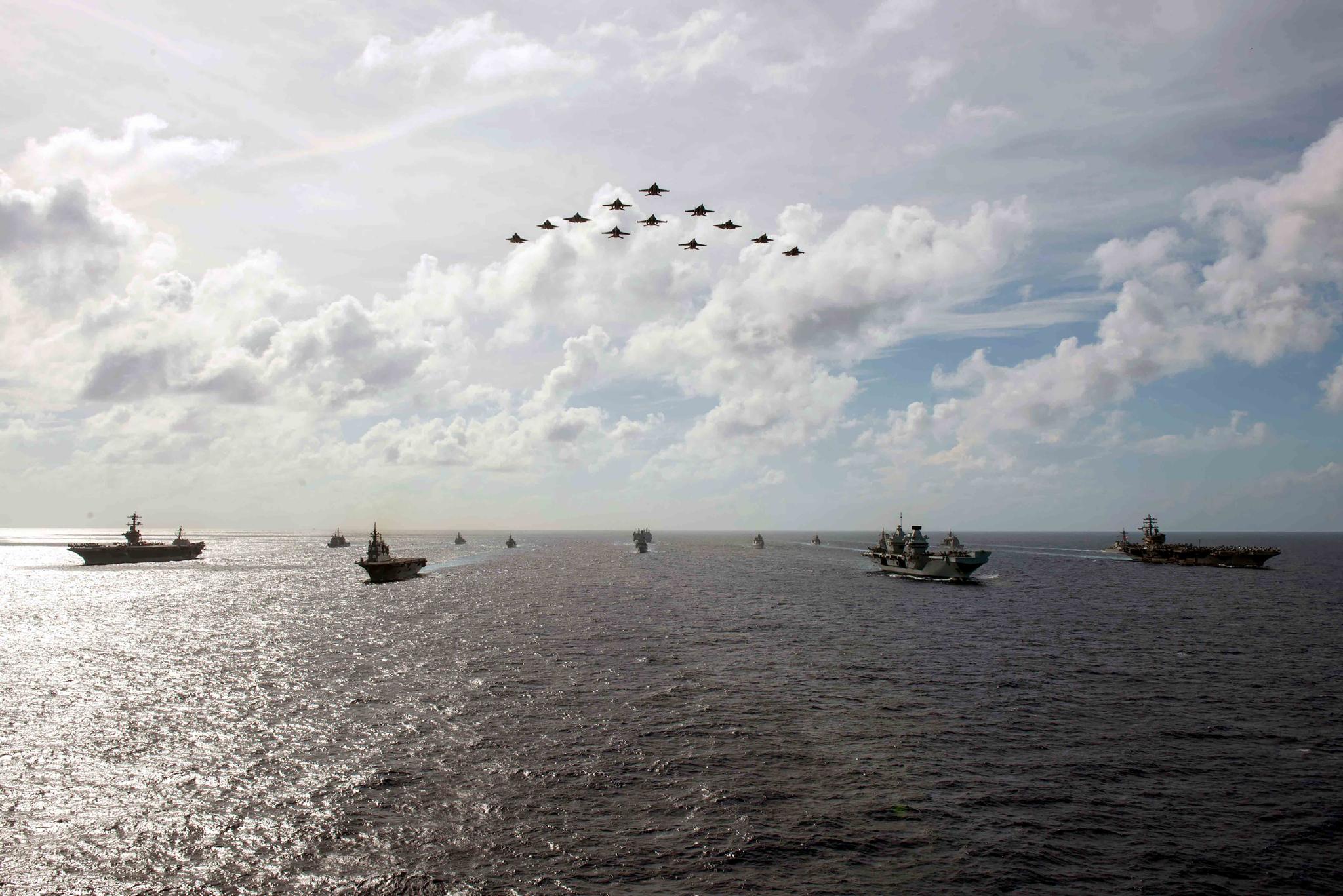 In this photo released by the U.S. Indo-Pacific Command, the United Kingdom's carrier strike group led by HMS Queen Elizabeth (R 08), and Japan Maritime Self-Defense Forces led by (JMSDF) Hyuga-class helicopter destroyer JS Ise (DDH 182) joined with U.S. Navy carrier strike groups led by flagships USS Ronald Reagan (CVN 76) and USS Carl Vinson (CVN 70) to conduct multiple carrier strike group operations in the Philippine Sea, on Oct. 3, 2021.