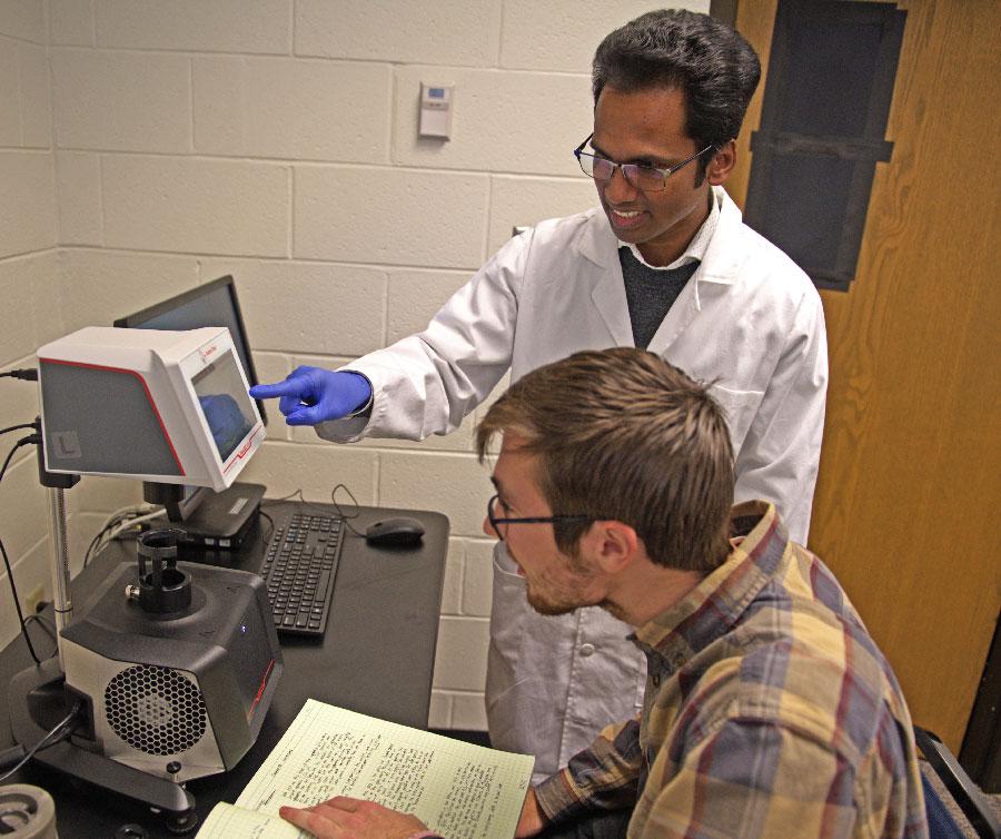 Dr. Mohan Pereira conducts research with a student in the new Cedarville University biophysics lab