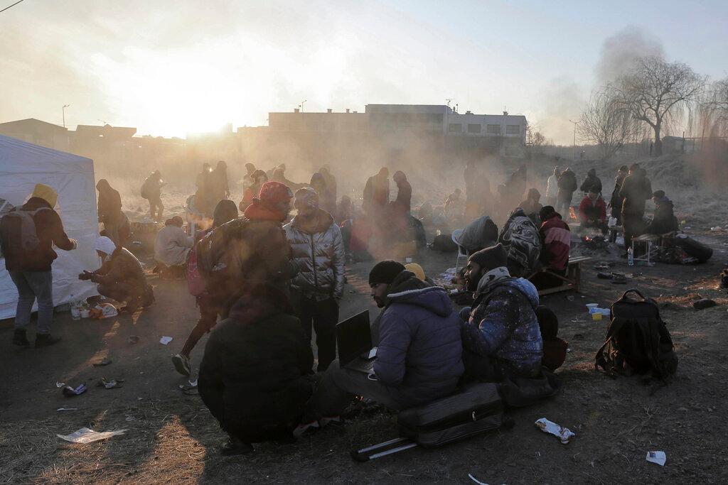 Refugees try to stay warm after fleeing the Russian invasion of Ukraine, at the Medyka border crossing in Poland
