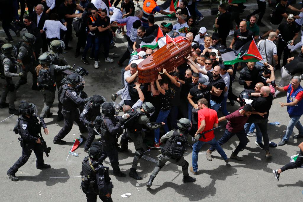 Israeli police confront with mourners as they carry the casket of slain Al Jazeera veteran journalist Shireen Abu Akleh during her funeral in east Jerusalem, Friday, May 13, 2022. Abu Akleh, a Palestinian-American reporter who covered the Mideast conflict for more than 25 years, was shot dead Wednesday during an Israeli military raid in the West Bank town of Jenin.
