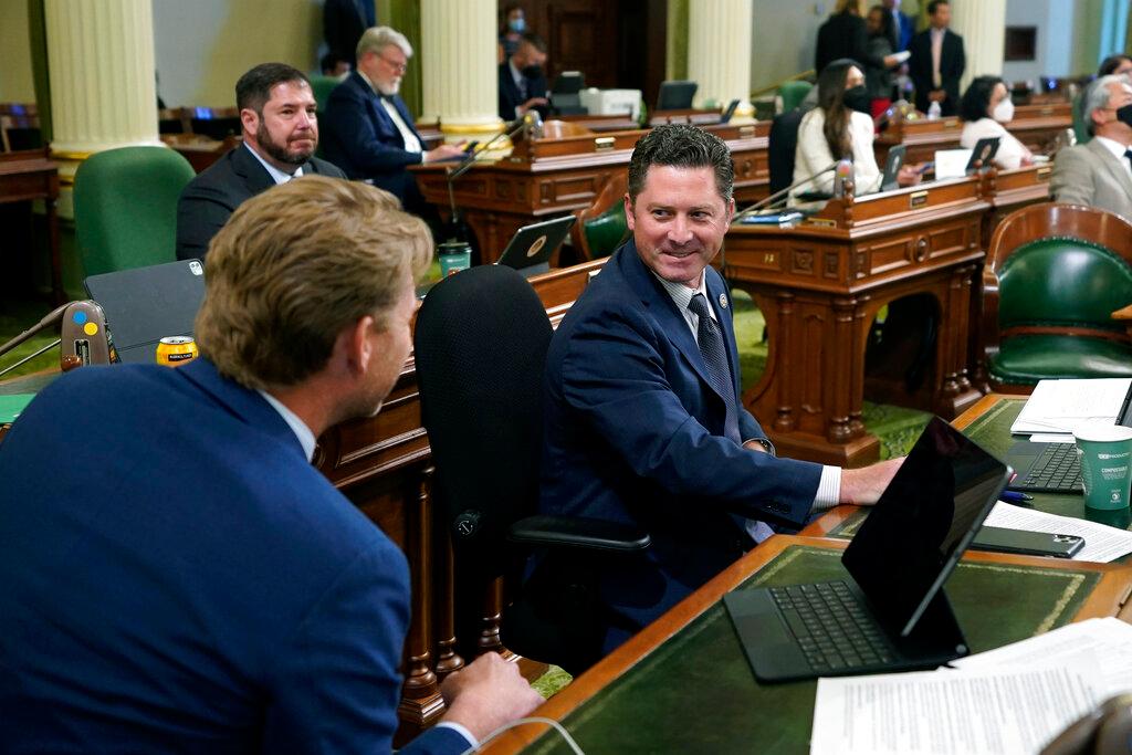 Assemblyman Jordon Cunningham, R-San Luis Obispo, right, smiles after his bill to hold social media companies responsible for harming children who have become addicted to their products was approved by the Assembly at the Capitol in Sacramento