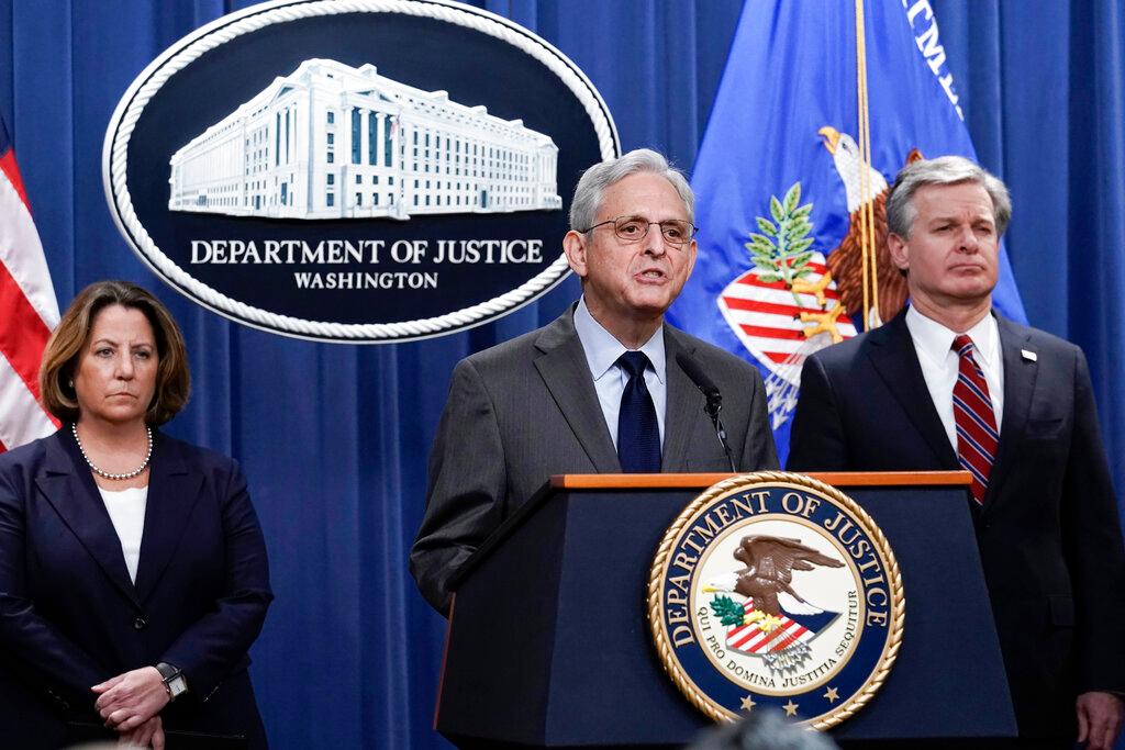 Attorney General Merrick Garland, center, flanked by Deputy Attorney General Lisa Monaco, left, and FBI Director Christopher Wray, speaks to reporters as they announce charges against two men suspected of being Chinese intelligence officers