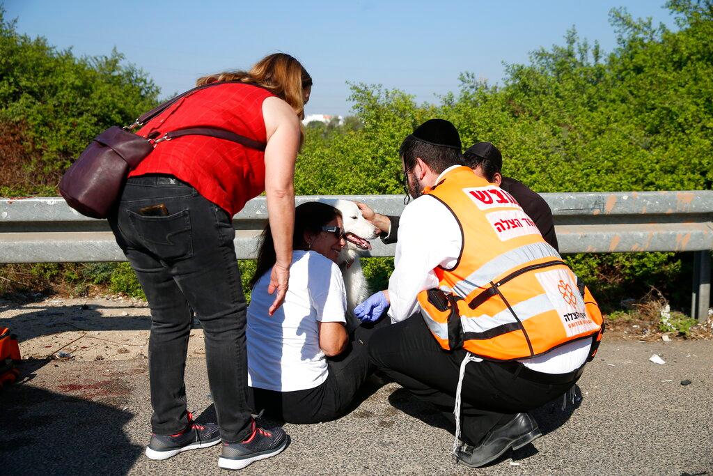 Paramedics treat a woman and her dog moments after a rocket fired by Palestinians militants from Gaza hit a main free way between Ashdod and Tel Aviv 