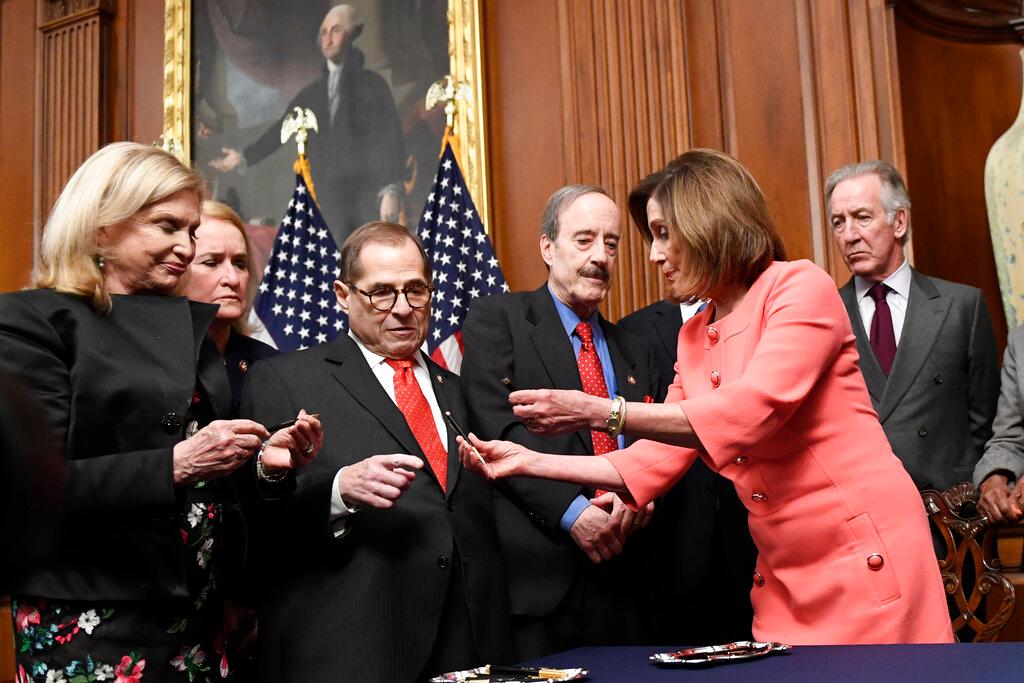 House Speaker Nancy Pelosi of Calif., second from right, gives pens to, from left, House Oversight and Government Reform Committee Chair Rep. Carolyn Maloney, D-N.Y., Rep. Sylvia Garcia, D-Texas, House Judiciary Committee Chairman Rep. Jerrold Nadler, D-N.Y., House Foreign Affairs Committee Chairman Rep. Eliot Engel, D-N.Y., and House Ways and Means Committee Chairman Rep. Richard Neal, D-Mass., after she signed the resolution to transmit the two articles of impeachment against President Donald Trump to the Senate for trial on Capitol Hill in Washington, Wednesday, Jan. 15, 2020. The two articles of impeachment against Trump are for abuse of power and obstruction of Congress.
